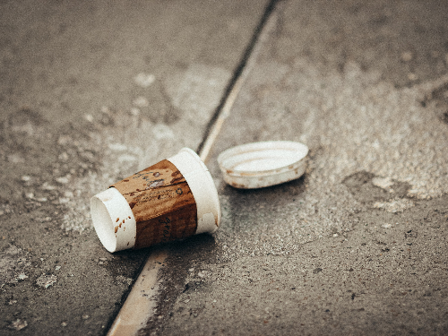 Coffee cup and remnants of beverage all over the sidewalk