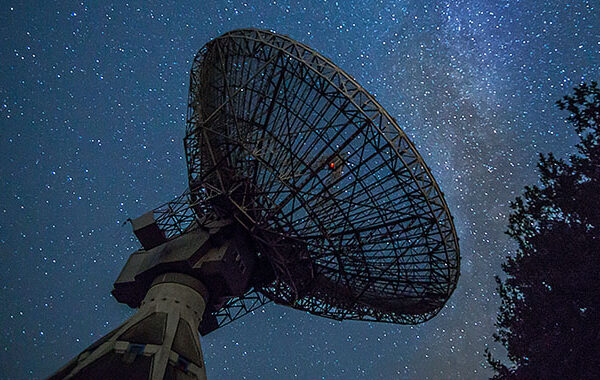 Radio telescope dish pointing at the night sky