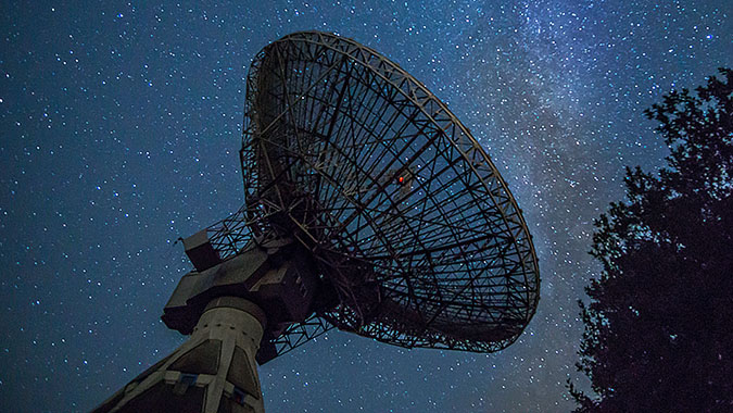 Radio telescope dish pointing at the night sky