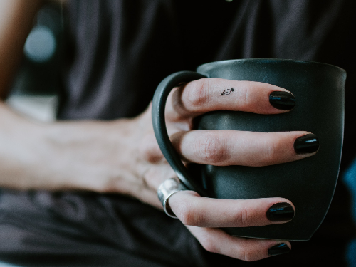 Human paints nails black in rebellion, and clutches mug like it's going out of style