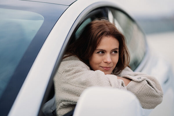 Woman resting in the window of a Tesla EV