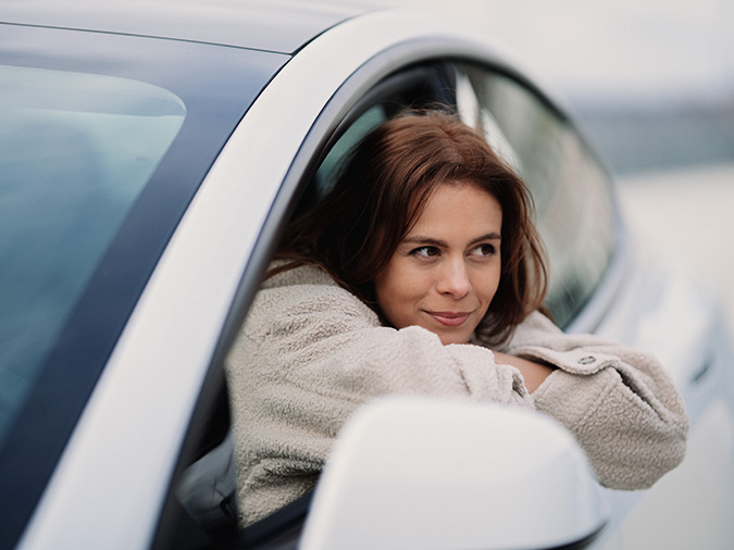 Woman resting in the window of a Tesla EV