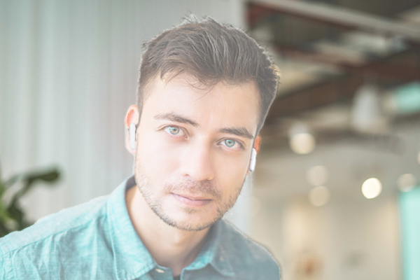 Man with earbuds disappearing into the background