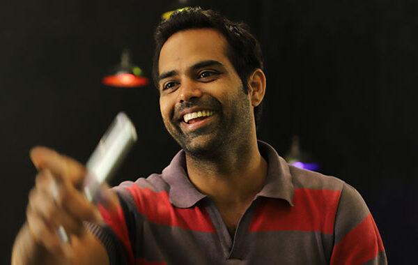 Man with smart phone pointing and smiling
