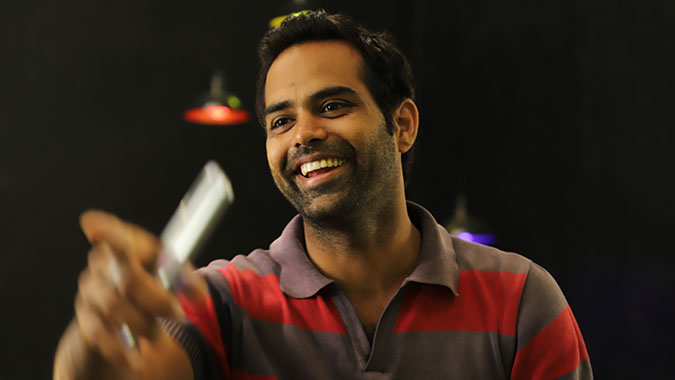 Man with smart phone pointing and smiling