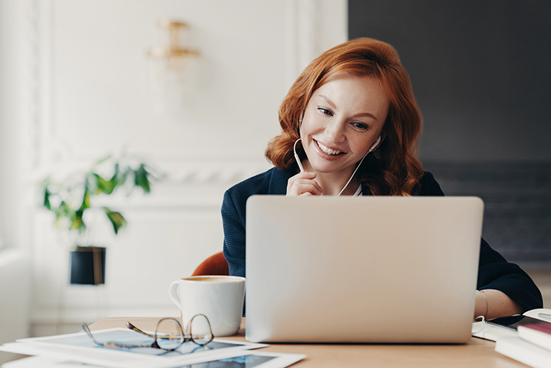 Woman with headphones on a laptop